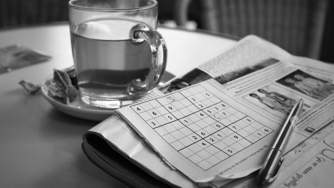 Newspaper with sudoku puzzle half completed
