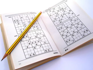 Sudoku puzzle book with pencil laying on top