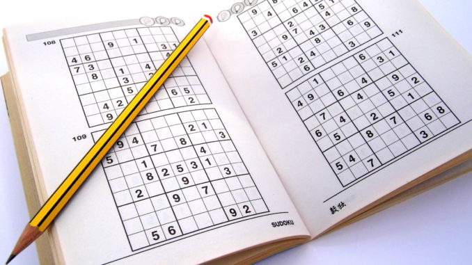 Sudoku puzzle book with pencil laying on top