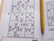 Sudoku puzzle book with pencil laying between the pages