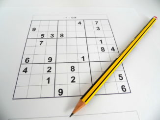 An evil sudoku puzzle with pencil laying across