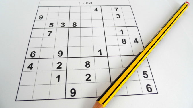 An evil sudoku puzzle with pencil laying across