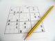 An evil sudoku puzzle with pencil laying across